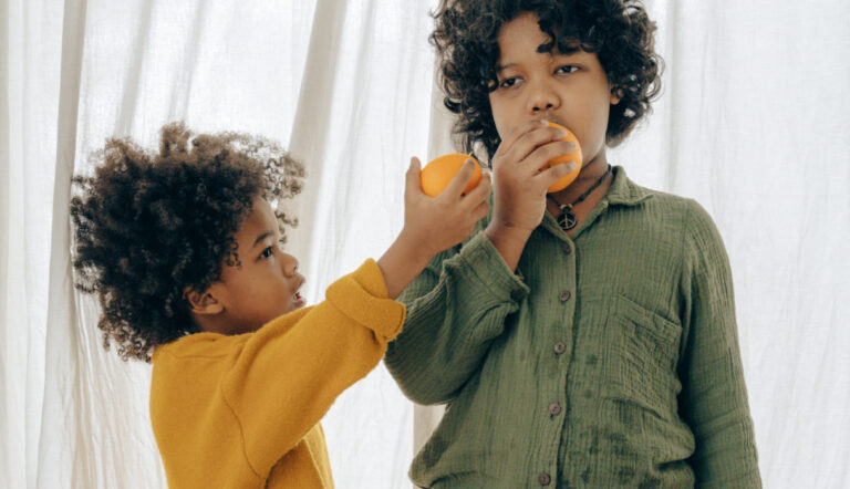 rekening houden met anderen / twee kindjes eten fruit