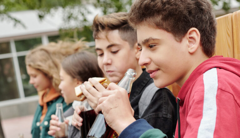 Jongens die een boterham eten, maar waarvan er een een pinda-allergie heeft