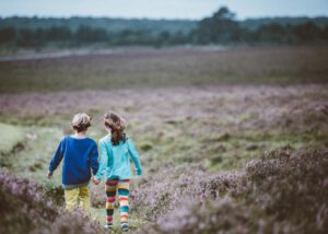 Een jongen en een meisje die hand in hand lopen omdat een ouder zijn zoon feministisch heeft opgevoed