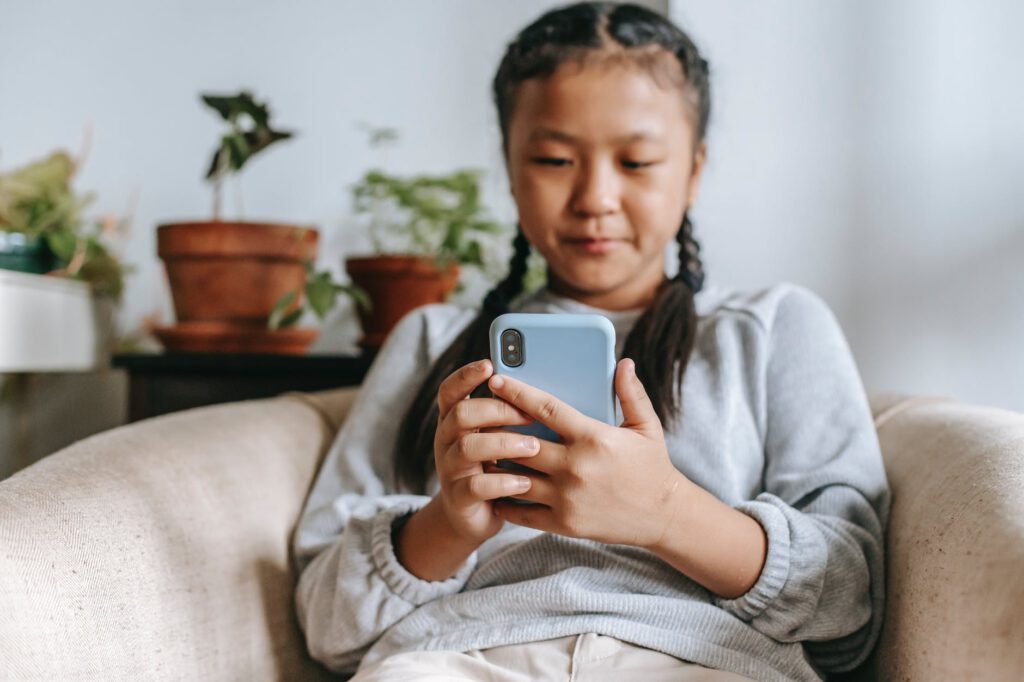 sociale media / meisje zit op de bank met telefoon