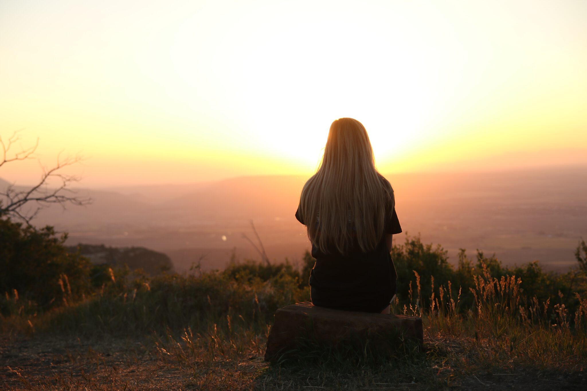 Geen vriendinnen. Meisje kijkt in haar eentje naar de zonsondergang