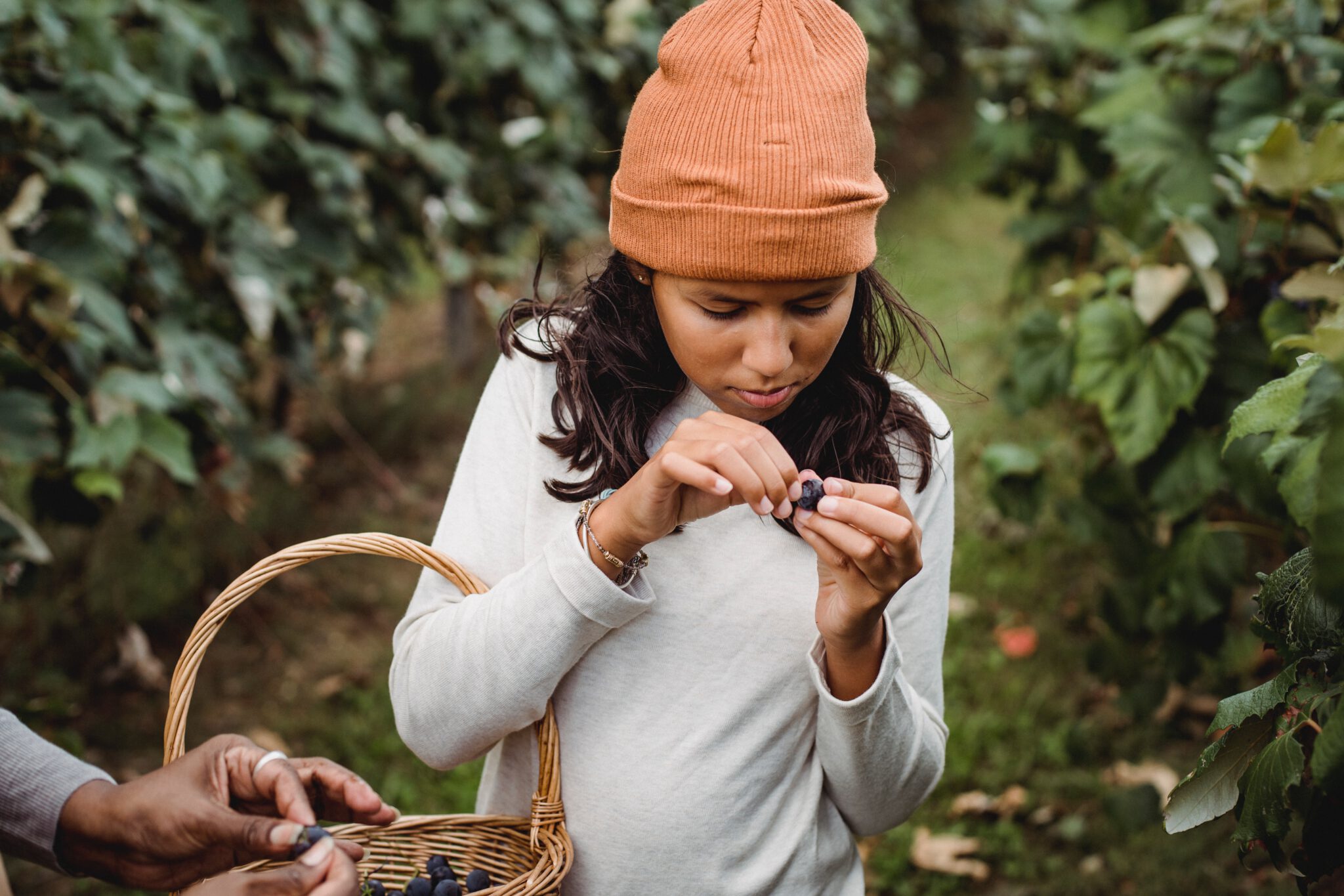 tieners gezond eten - meisje met beanie in fruittuin